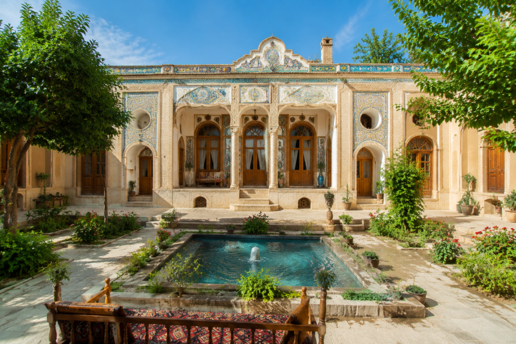 نمای خارجی خانه کلنگی بازسازی شده با باغچه و آب‌نما، ترکیبی از معماری سنتی و امکانات مدرن